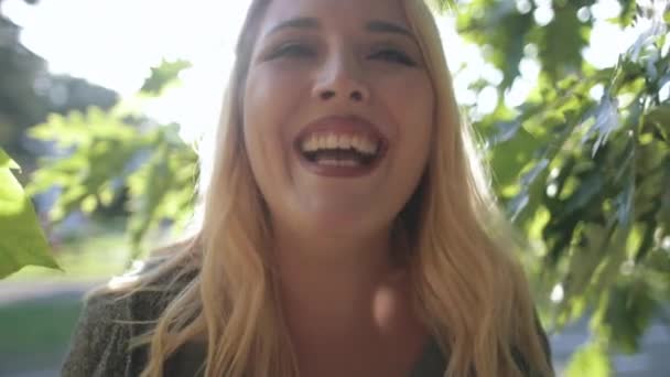 Jeune femme rire arbre feuillage arrière-plan Bokeh — Video