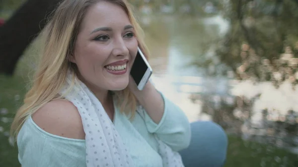 Mulher loira Plus Size Talk Smartphone Sente-se perto do lago — Fotografia de Stock