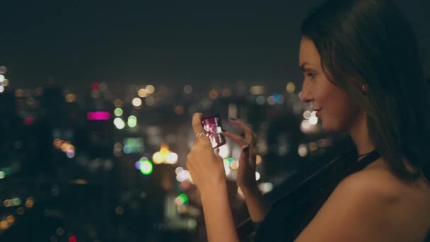 Симпатичная дама сняла ночной город с панорамным видом — стоковое видео