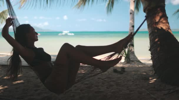 Γυναίκα χαλαρώνοντας στην αιώρα sibaltan τροπική παραλία — Αρχείο Βίντεο