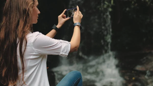 Jovem viajante perto de cachoeira na floresta tropical — Fotografia de Stock