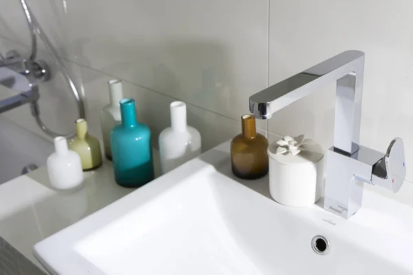 Salle de bain avec lavabo et bouteilles en verre — Photo