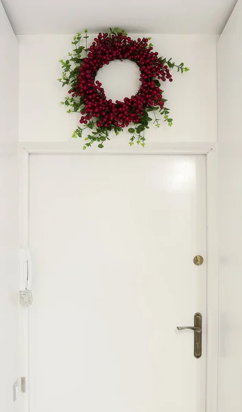 Красный венок над входной дверью — стоковое фото
