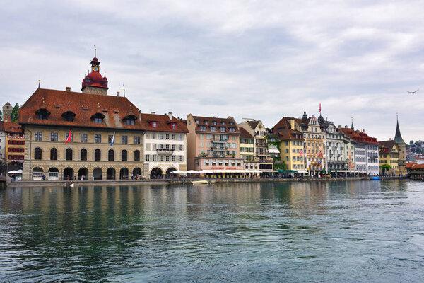 Lucerne, Switzerland - June 14, 2017: Historic city center of Lucerne, Town Hall clock tower and river Reuss shown at early morning