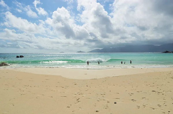 未確認の観光客は島で最も人気のあるビーチから美しい砂浜Anse Soleil 1に休息を持っています — ストック写真
