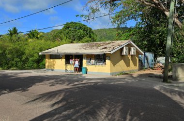 Mahe, Seyşeller - 7 Temmuz 2011: Seyşel Adaları 'ndaki bir sokakta küçük bir dükkana giren yerel bir kadın
