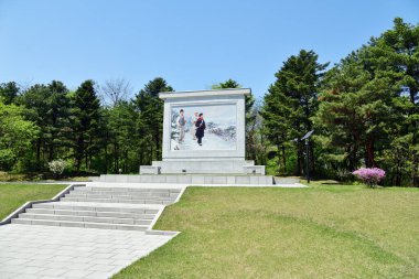 Kuzey Kore, Pyongyang - 1 Mayıs 2019: Mangyongdae Parkı 'nda Kim Il Sung' un çocukluğundan bir sahneyi resmeden propaganda pankartı