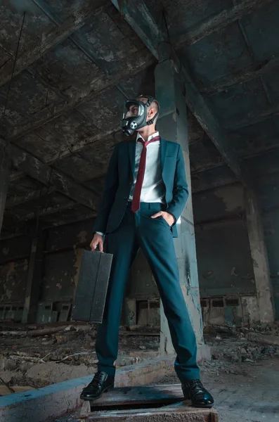 De foto van de man in gasmasker met koffer in de hand — Stockfoto