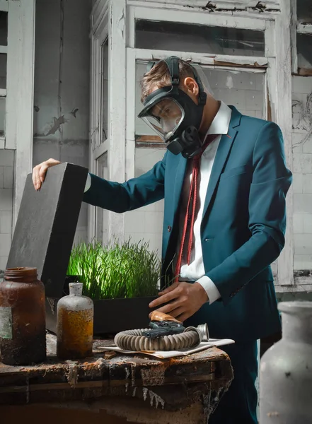 bavul ile gaz maskeli adam fotoğraf. Çantada filizlenmiş buğday