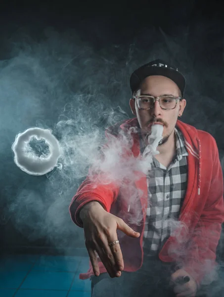 Portret van een man in een plaid shirt met een baard. elektronische sigaretten rookt. nicotineverslaving — Stockfoto