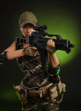 askeri tulum airsoft kız pus karanlık bir arka plan üzerinde elinde bir silah ile poz