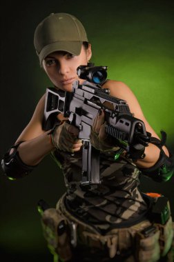 askeri tulum airsoft kız pus karanlık bir arka plan üzerinde elinde bir silah ile poz