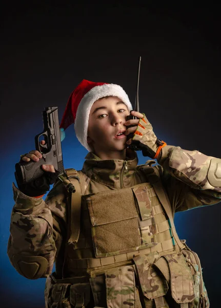Asker üniformalı bir genç ve Noel Baba şapkası radyoda konuşuyor. — Stok fotoğraf