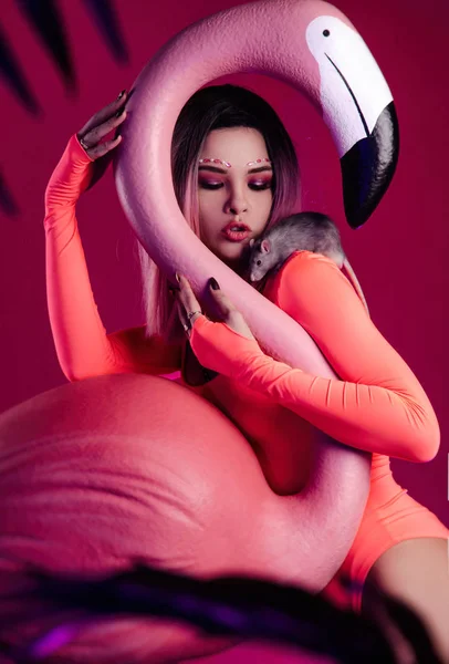Büyük bir Flamingo figürü ve canlı bir faresi olan parlak vücutlu bir kız. — Stok fotoğraf