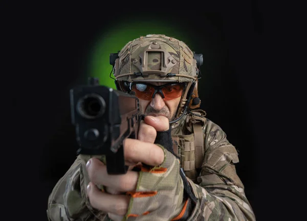 Ein Soldat in Militärkleidung mit Waffe auf dunklem Hintergrund — Stockfoto