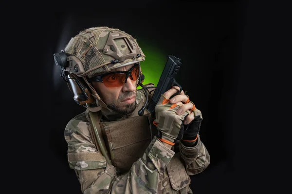 Чоловічий солдат у військовому одязі зі зброєю на темному тлі — стокове фото