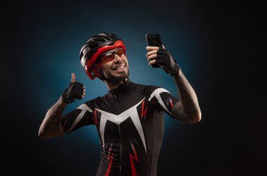 Bisiklet kasklı bir bisikletçi selfie çekiyor.