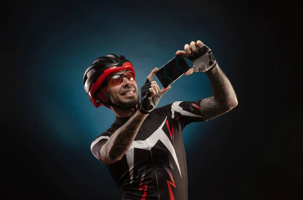Chico es un ciclista en un casco de bicicleta se toma una selfie — Foto de Stock