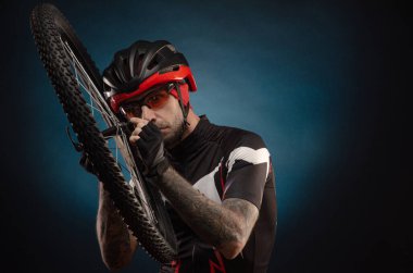 Bisiklet kasklı bisikletli bir adam ve bisiklet tekerleği.