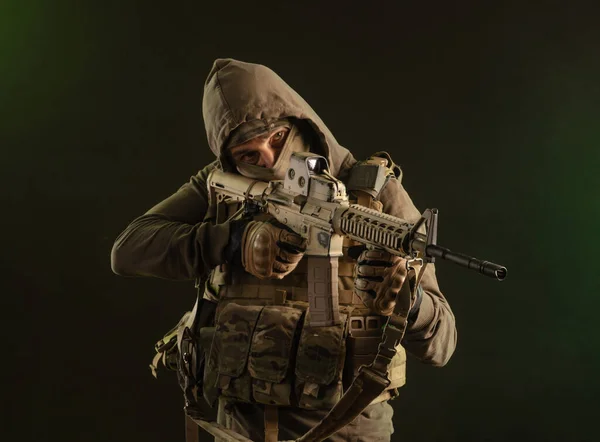 Soldat-sabotör i militära kläder med vapen på en mörk bakgrund — Stockfoto
