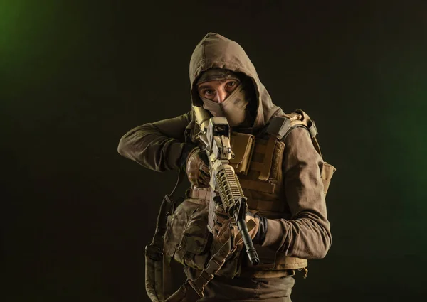 Солдат-табуретка у військовому одязі зі зброєю на темному тлі — стокове фото