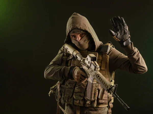 Voják-sabotér ve vojenském oblečení se zbraněmi na tmavém pozadí — Stock fotografie