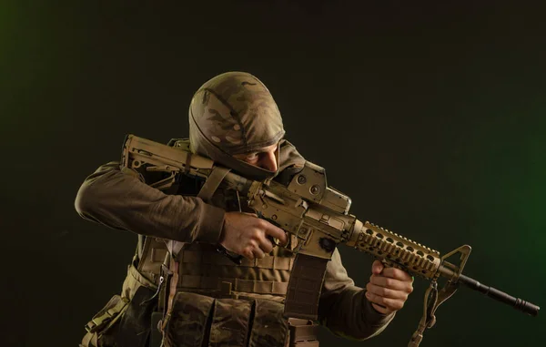 Soldaat-saboteur in militaire kleding met wapens op een donkere achtergrond — Stockfoto