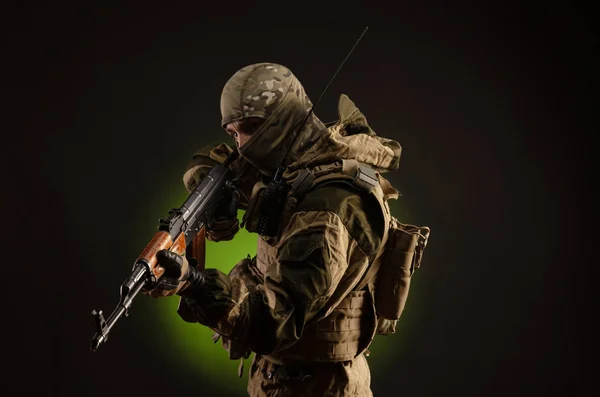 Soldado milícia sabotador em roupas militares com um fuzil Kalashnikov em um fundo escuro — Fotografia de Stock