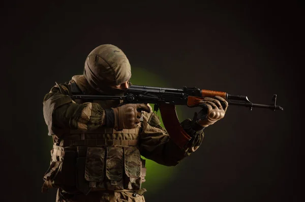 Soldier militia saboteur in military clothing with a Kalashnikov rifle on a dark background — ストック写真