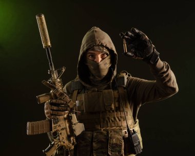 a soldier-saboteur in military uniform with a weapon on a dark background shows a bullet