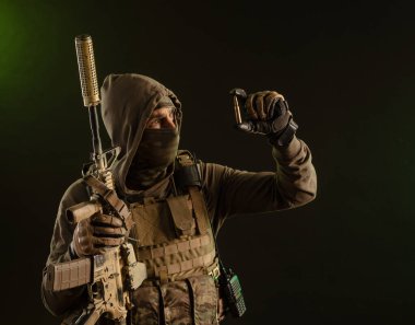 a soldier-saboteur in military uniform with a weapon on a dark background shows a bullet
