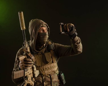 a soldier-saboteur in military uniform with a weapon on a dark background shows a bullet