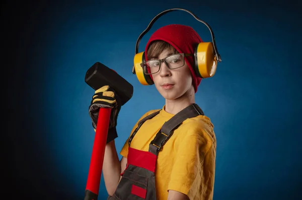 Das Kind das Bauarbeiter-Kostüm, das mit einem Arbeitsgerät posiert — Stockfoto