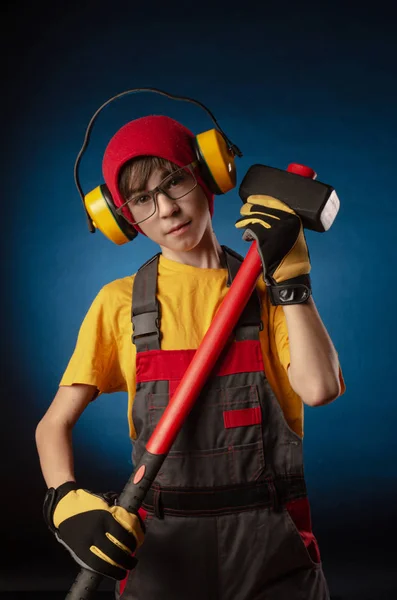 A criança o traje de Construtor posando com uma ferramenta de trabalho — Fotografia de Stock