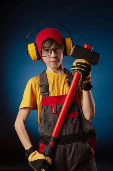 Das Kind das Bauarbeiter-Kostüm, das mit einem Arbeitsgerät posiert — Stockfoto