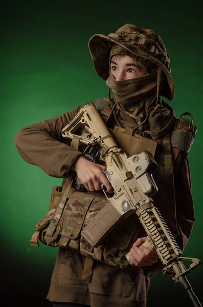 A boy in military uniform with a gun — Stock Photo, Image