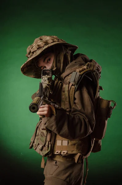 A boy in military uniform with a gun — Stock Photo, Image