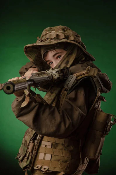 A boy in military uniform with a gun — Stockfoto