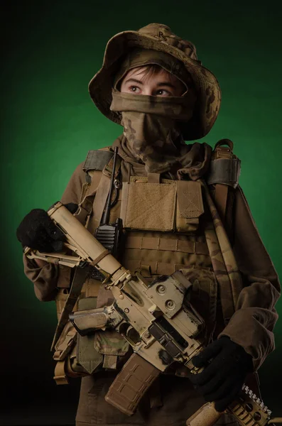 A boy in military uniform with a gun — Stock Photo, Image