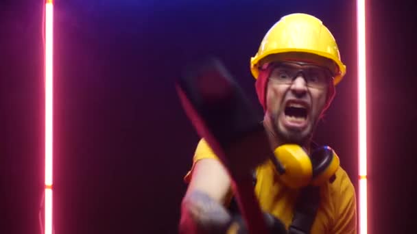 A male construction worker in a hard hat hits with a sledgehammer — Stock video