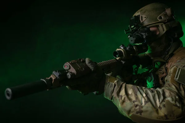 Seorang tentara dalam pakaian militer dengan alat penglihatan malam dan pada latar belakang gelap — Stok Foto