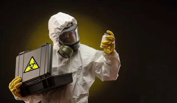 Чоловік у біологічному захисному костюмі з газовою маскою з ліками від коронавірусу — стокове фото