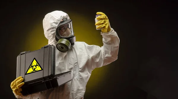 Un hombre con un traje de protección biológica que lleva una máscara de gas con medicamentos para el coronavirus — Foto de Stock