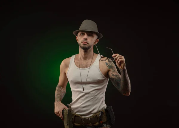 Un atlético con un tatuaje posa con un arma — Foto de Stock