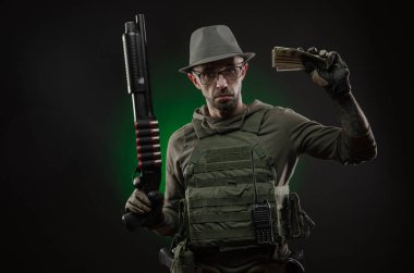 Dövmeli bir sporcu pompalı tüfekle poz veriyor.
