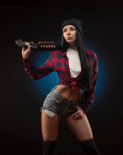 검은 배경에 산탄총을 든 체크 셔츠를 입은 소녀 — 스톡 사진