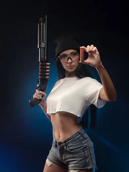 The girl on a dark background with a shotgun — Stock Photo, Image