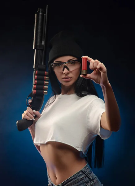 La fille sur le fond sombre avec le fusil de chasse — Photo