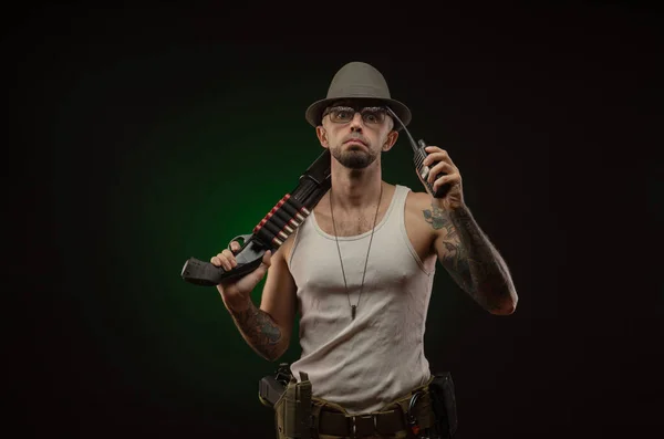 Egy tetovált atlétikai fickó egy puskával pózol. — Stock Fotó