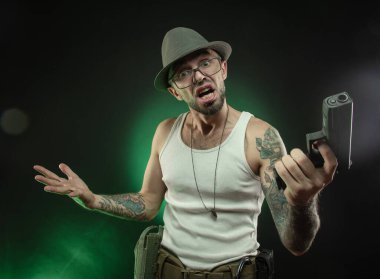 an athletic guy with a tattoo poses with a pistol clipart